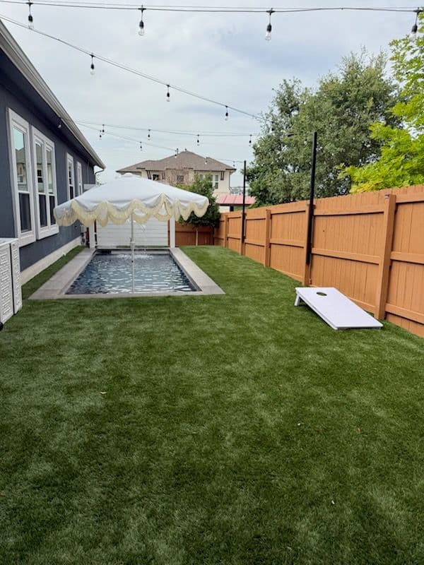 Backyard Oasis with Artificial Turf and Lighting image